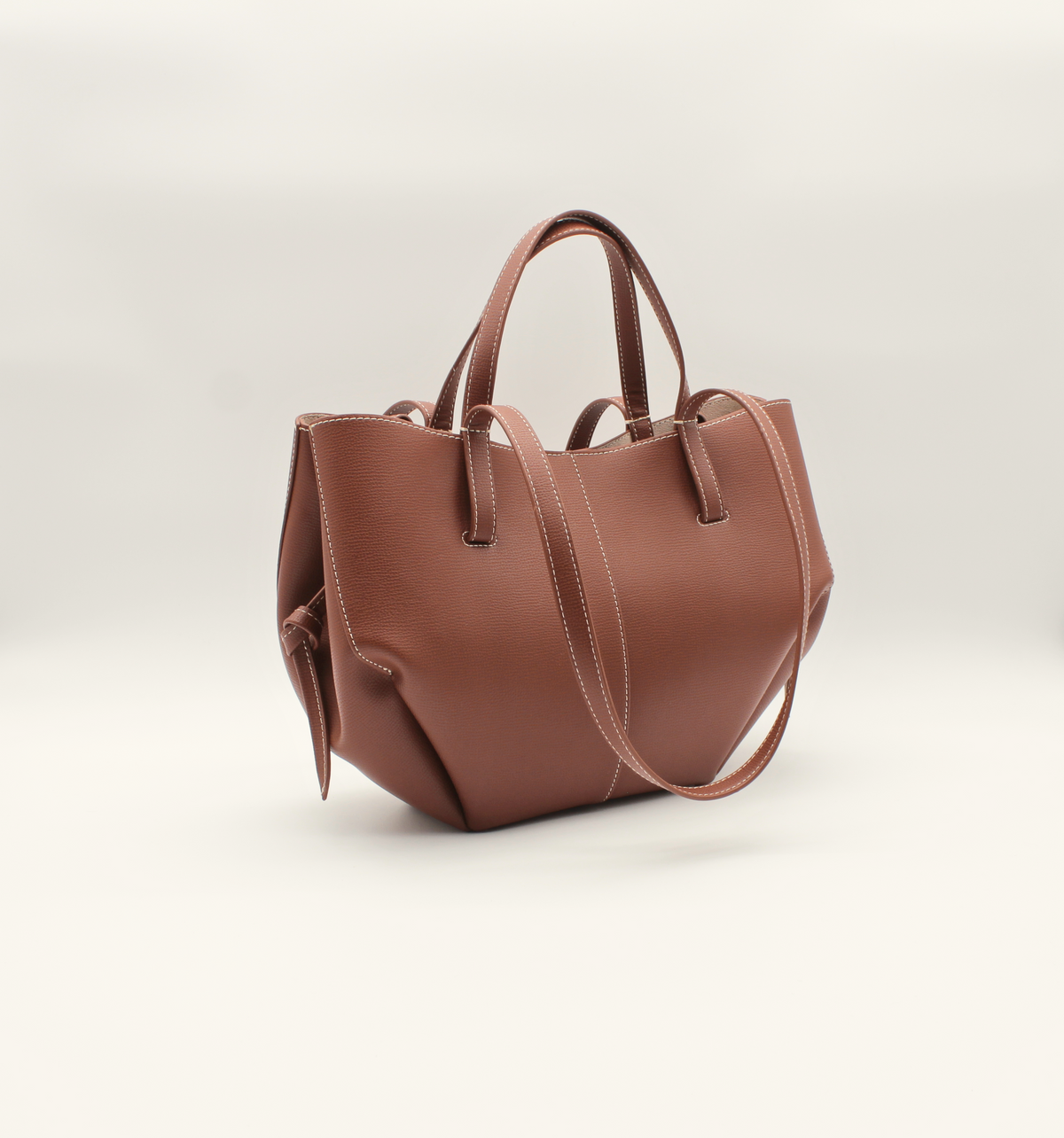 Mini Tote Bag Maila in Cognac, schräge Seitenansicht mit minimalistischer Silhouette